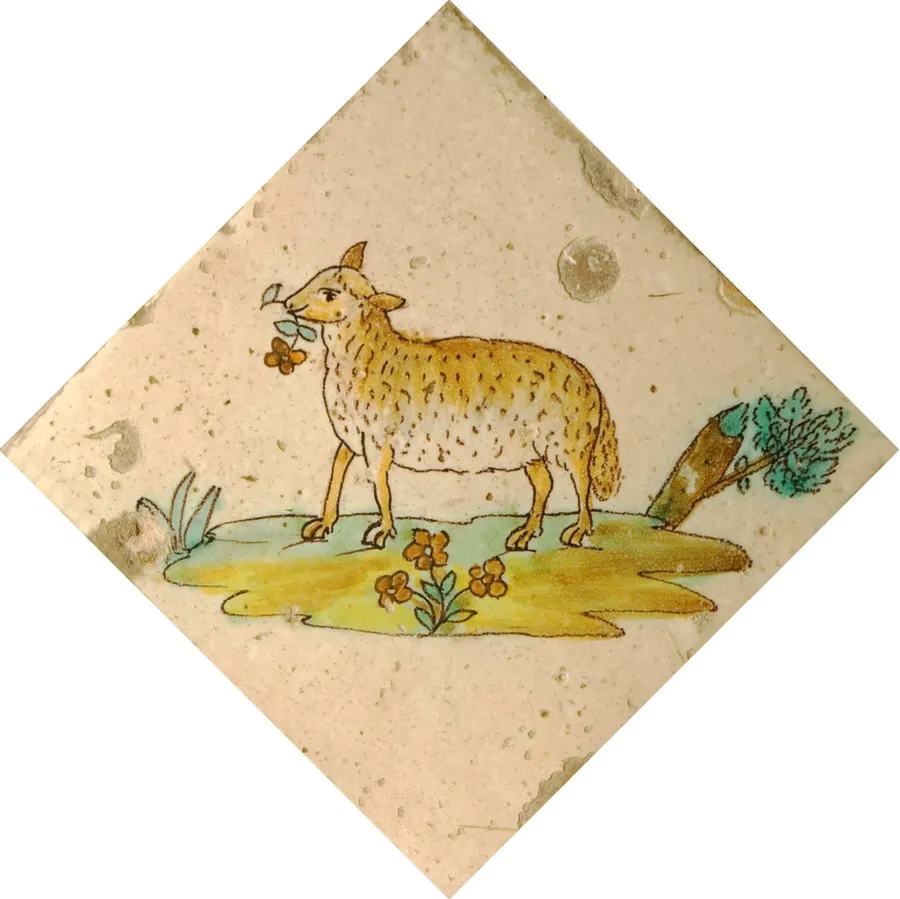 Ovella amb una flor a la boca sobre illeta diagonal amb fulles, rama i vegetació.